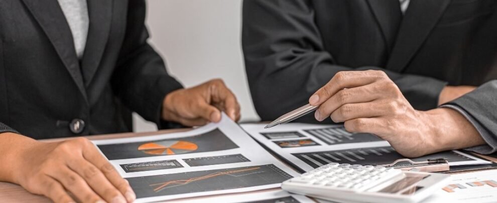 people in suits looking at graphs